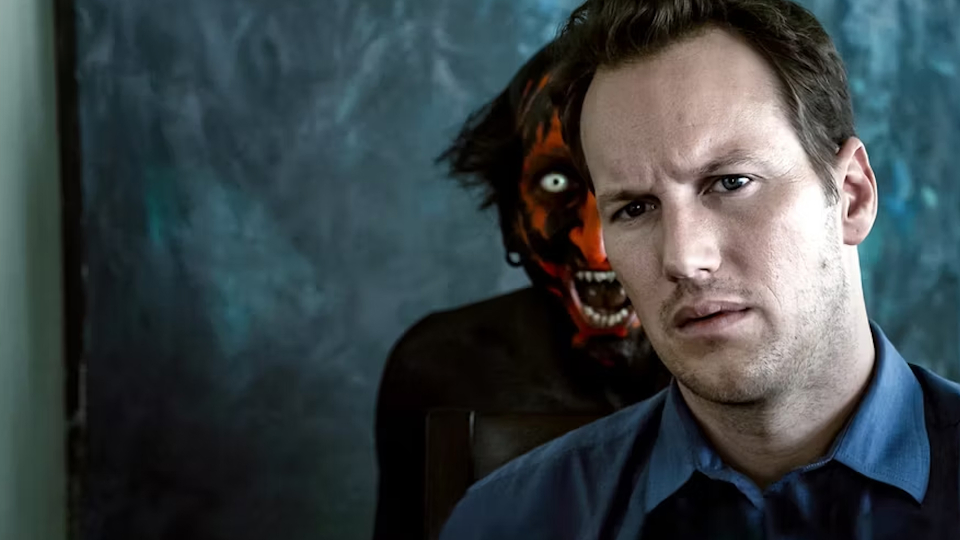 patrick wilson being haunted by a red and black demon, positioned ominously behind him
